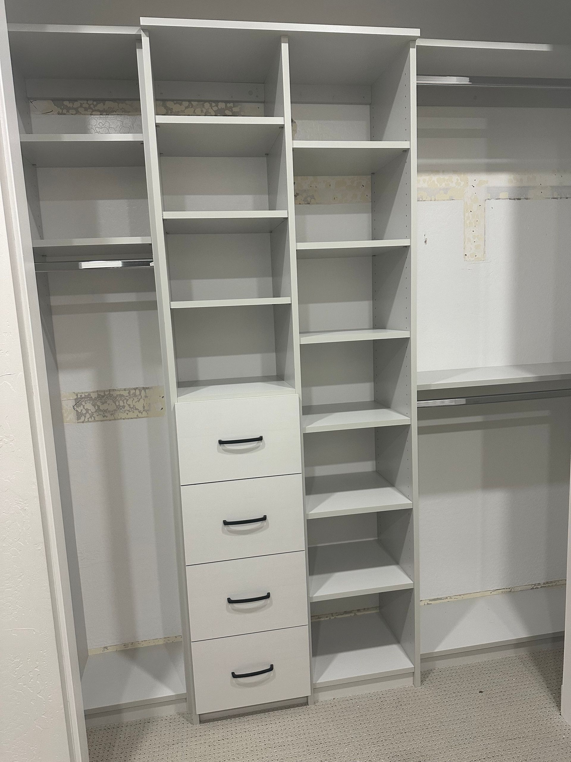 A walk in closet with lots of shelves and drawers