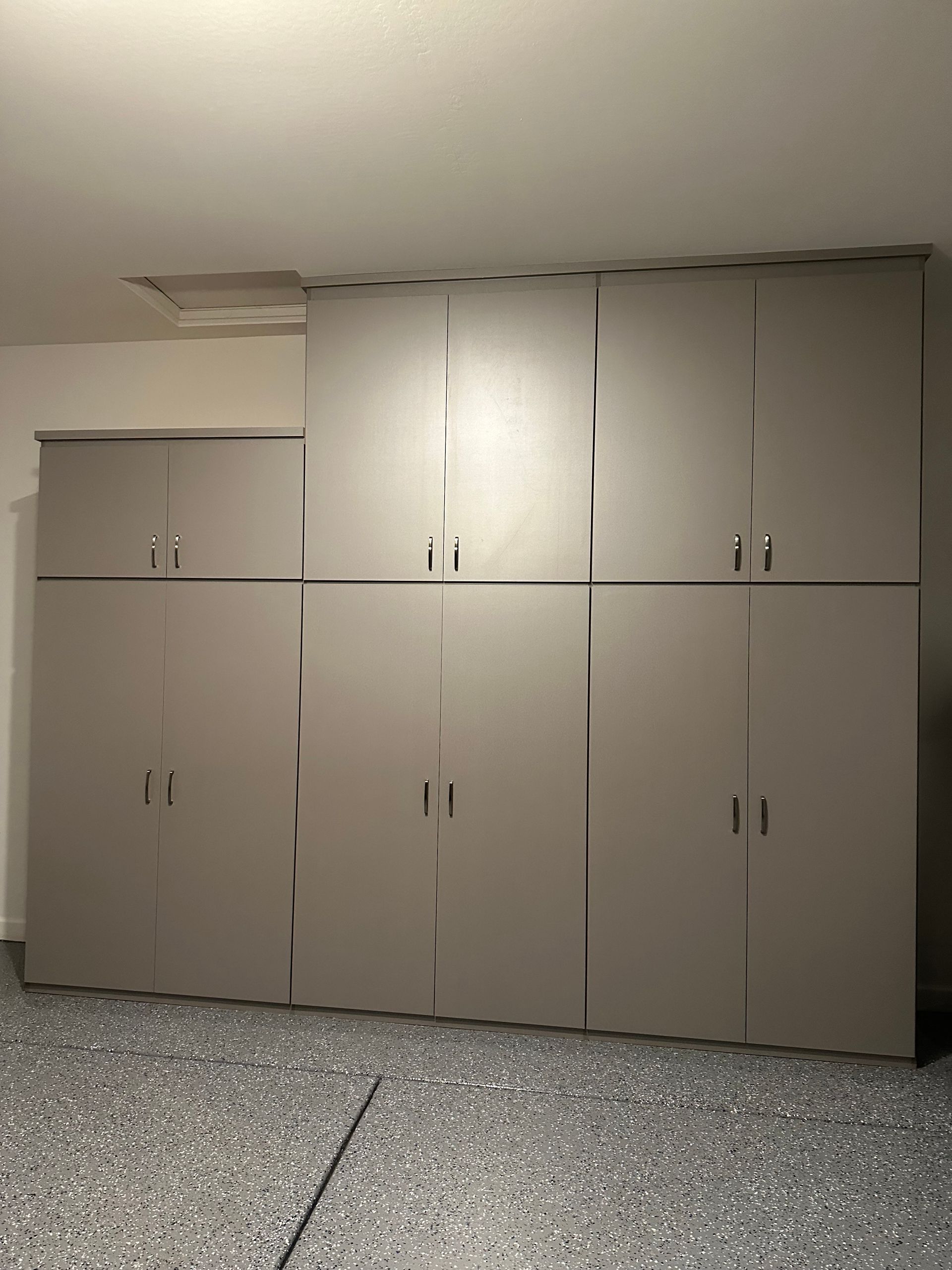 A garage with a lot of cabinets and a concrete floor.