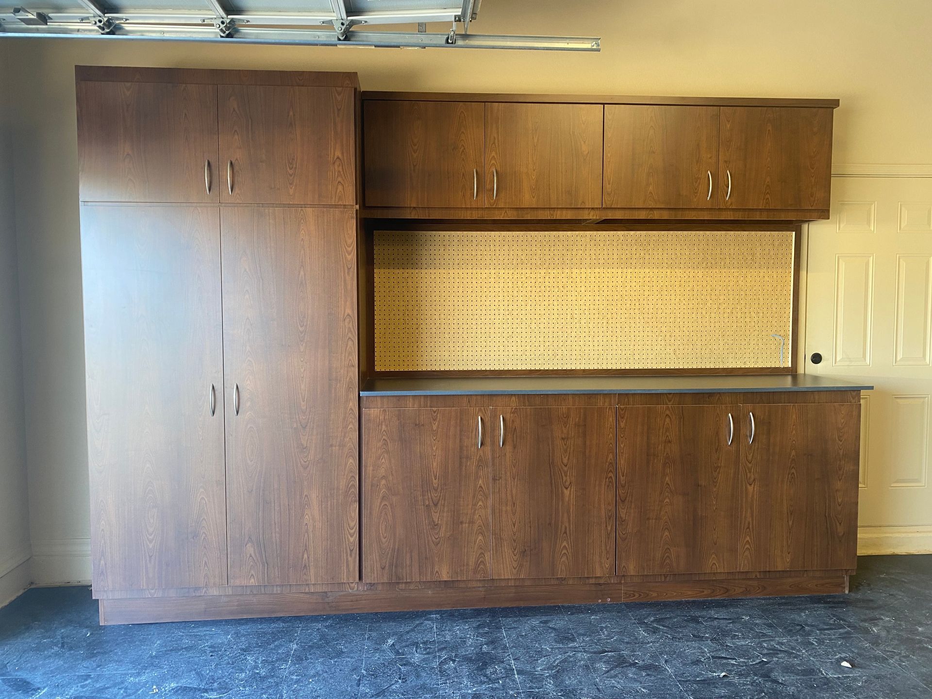 A garage with lots of cabinets and a workbench.