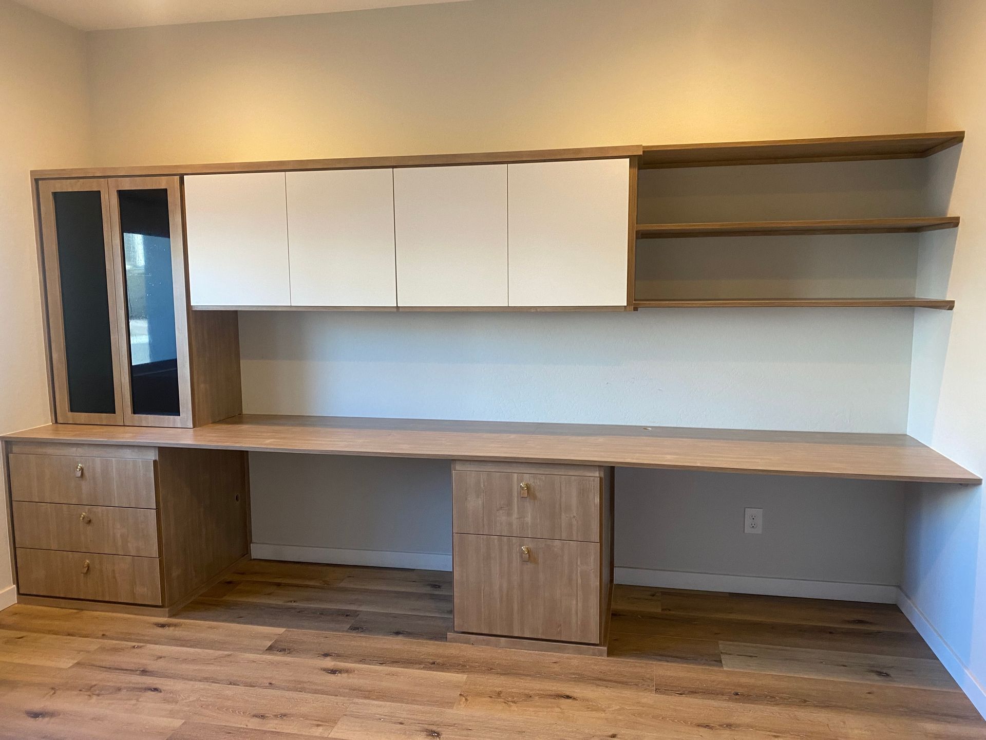 A large wooden desk with drawers and shelves in a room.