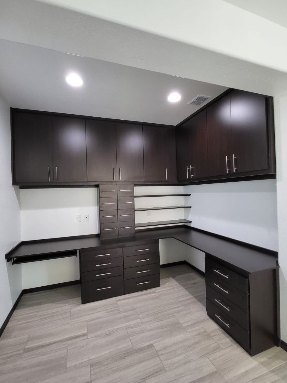 A room with a desk and drawers in it