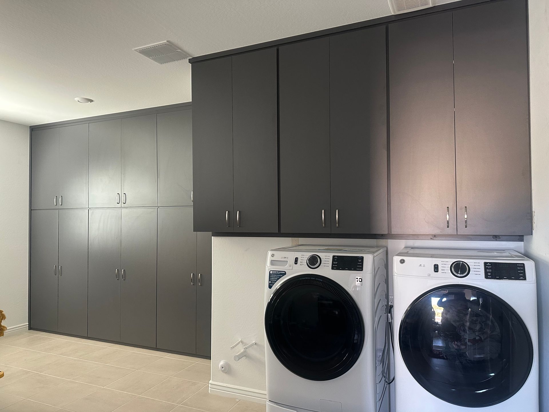 A laundry room with a washer and dryer and lots of cabinets.