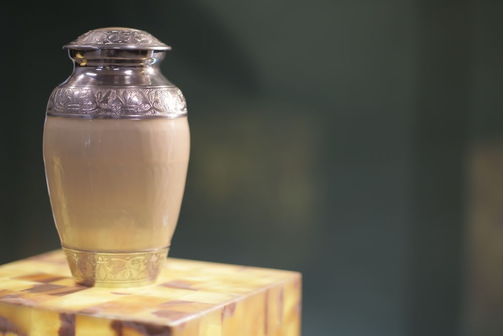 A Small Urn is Sitting on Top of a Wooden Box — Becker Family Funerals In Port Macquarie, NSW
