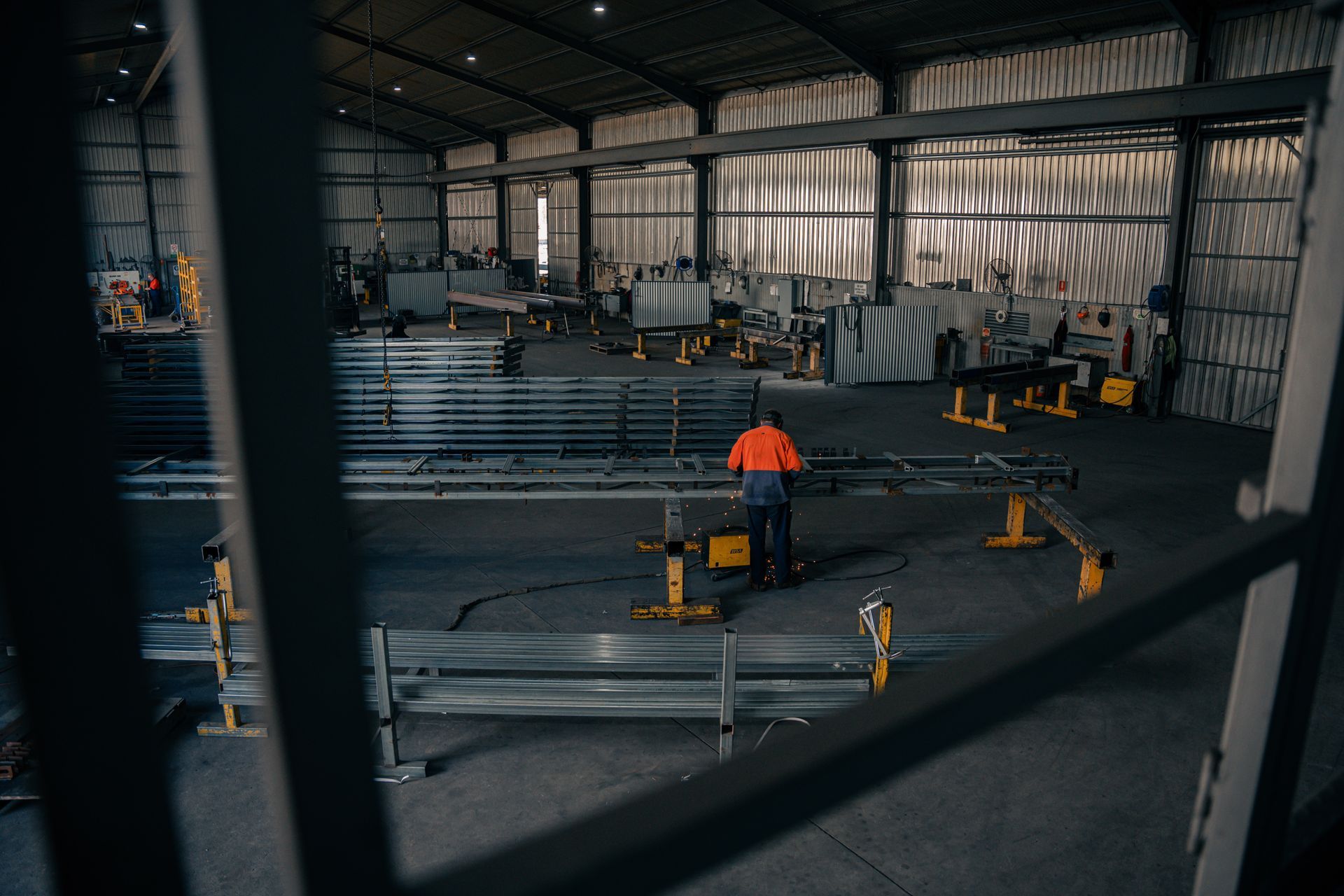 A man is standing in the middle of a large warehouse.