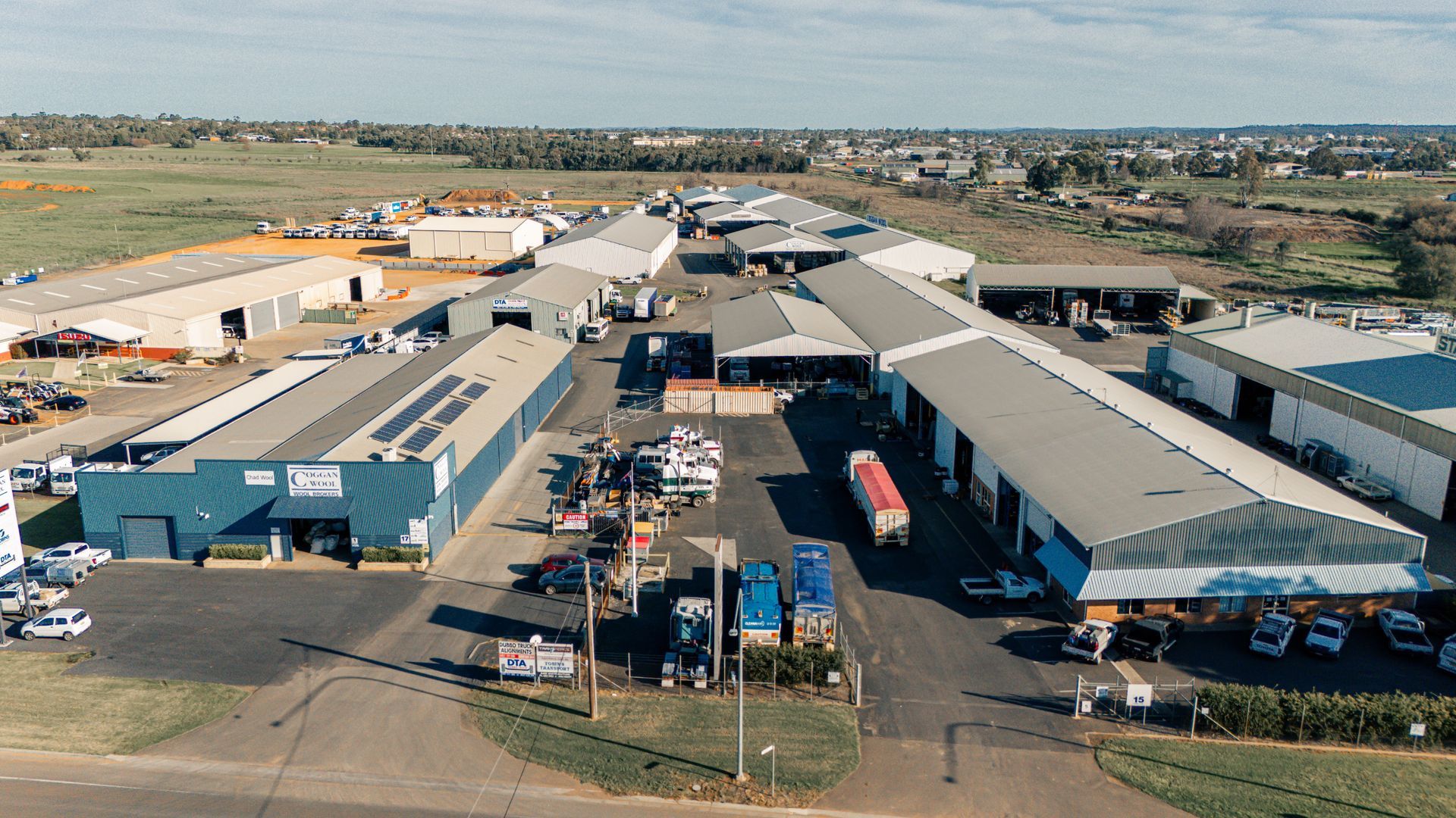 An aerial view of a warehouse with a lot of trucks parked in front of it