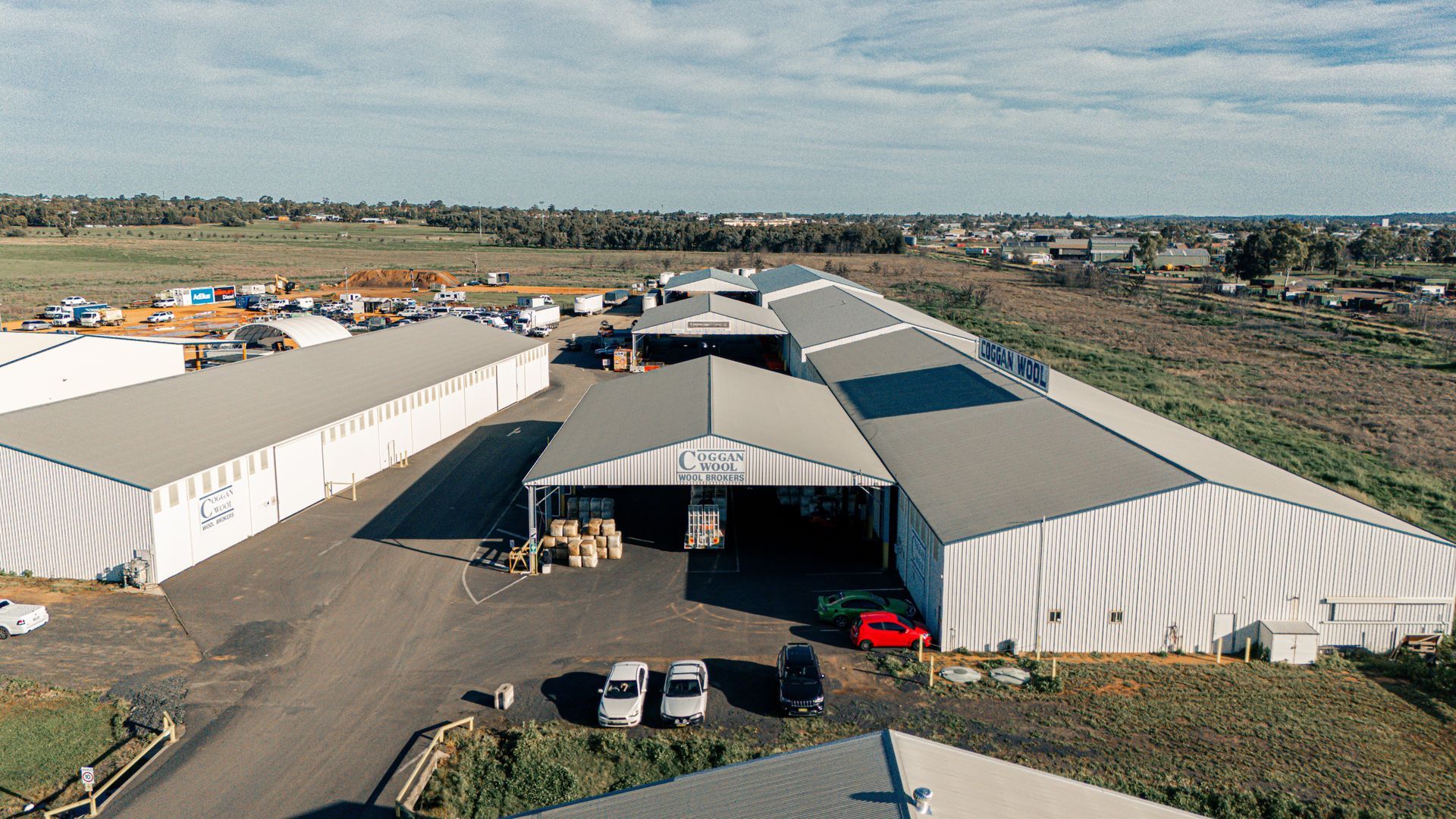 An aerial view of a large warehouse with cars parked in front of it.