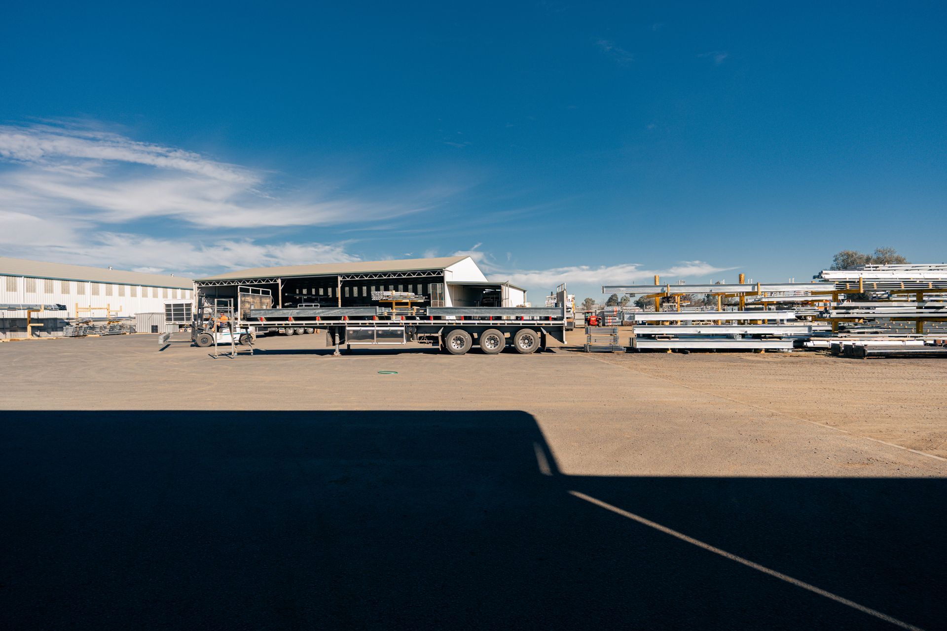 A truck is parked in a parking lot in front of a building.