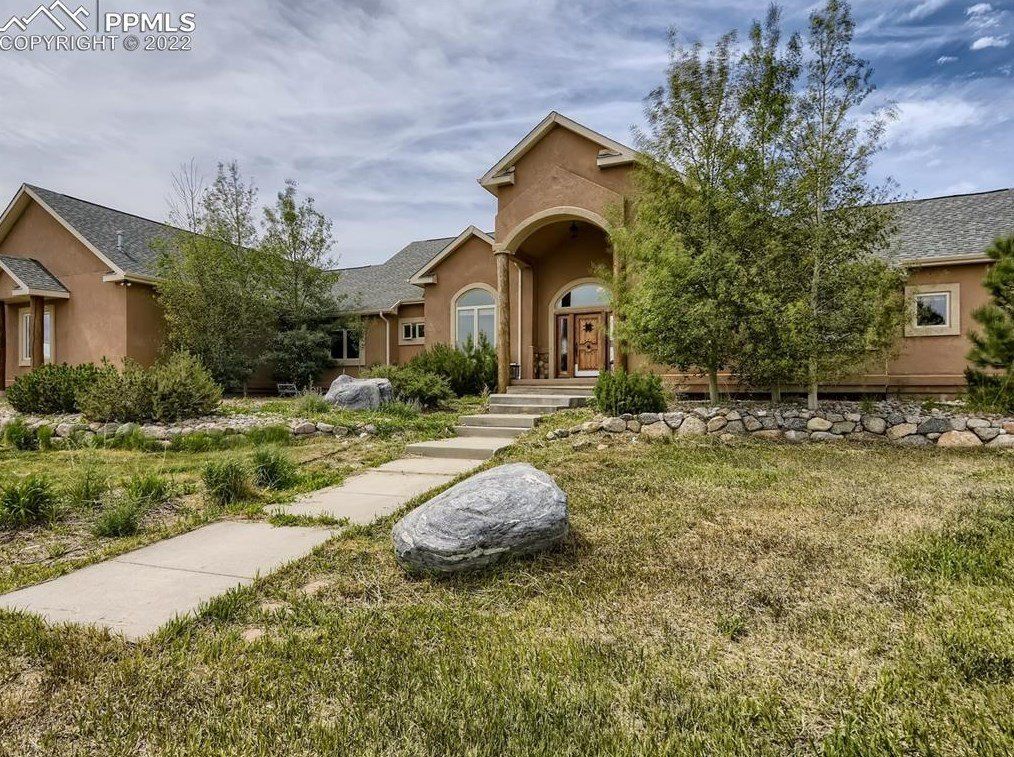 A large house with a large rock in front of it