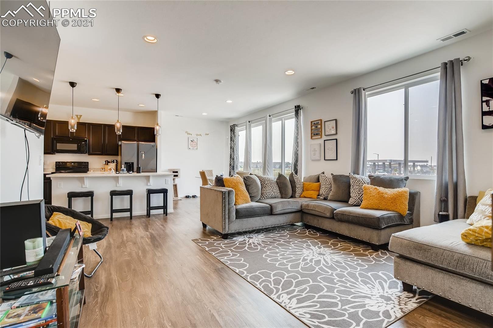A living room with a large sectional couch and a rug.