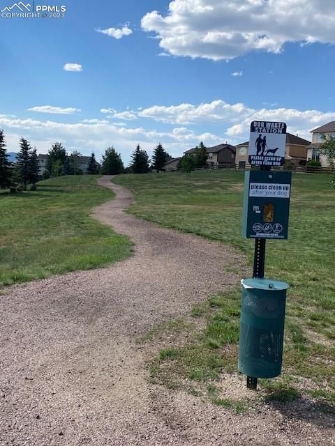 A dirt path in a park with a sign that says no dogs allowed