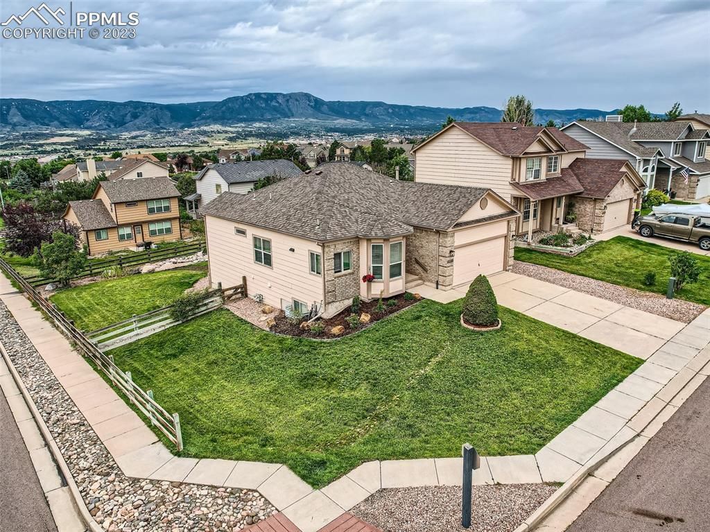 An aerial view of a house with a large lawn in front of it.