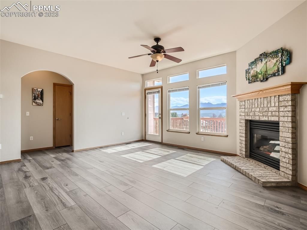 A living room with a fireplace and a ceiling fan