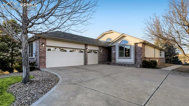 A house with a large driveway and two garage doors