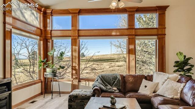 A living room with a couch , fireplace , and lots of windows.