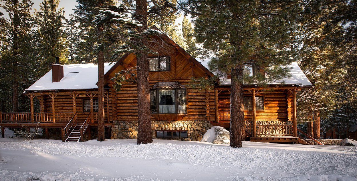 A log cabin in the middle of a snowy forest.
