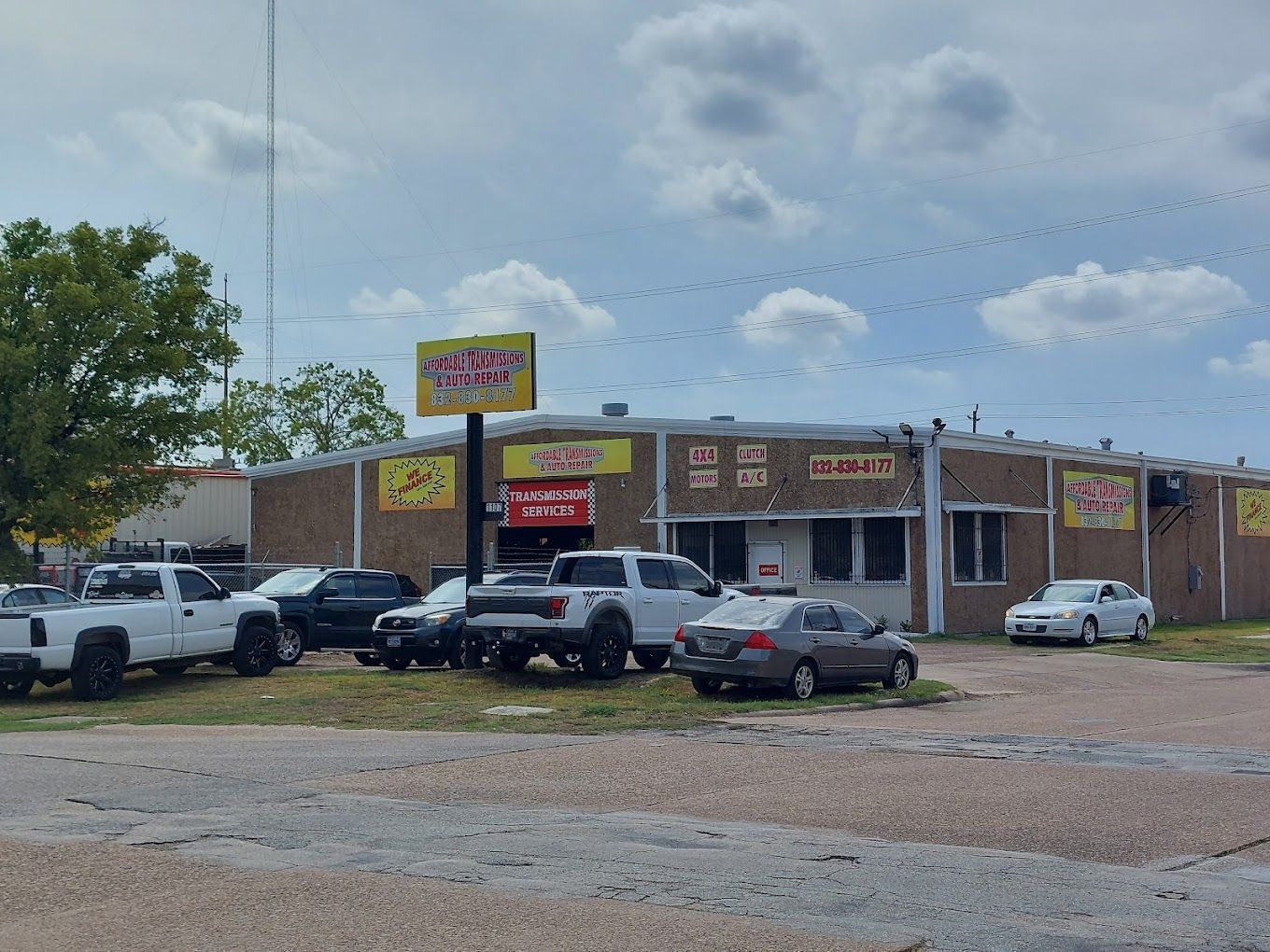 A lot of cars are parked in front of a building.