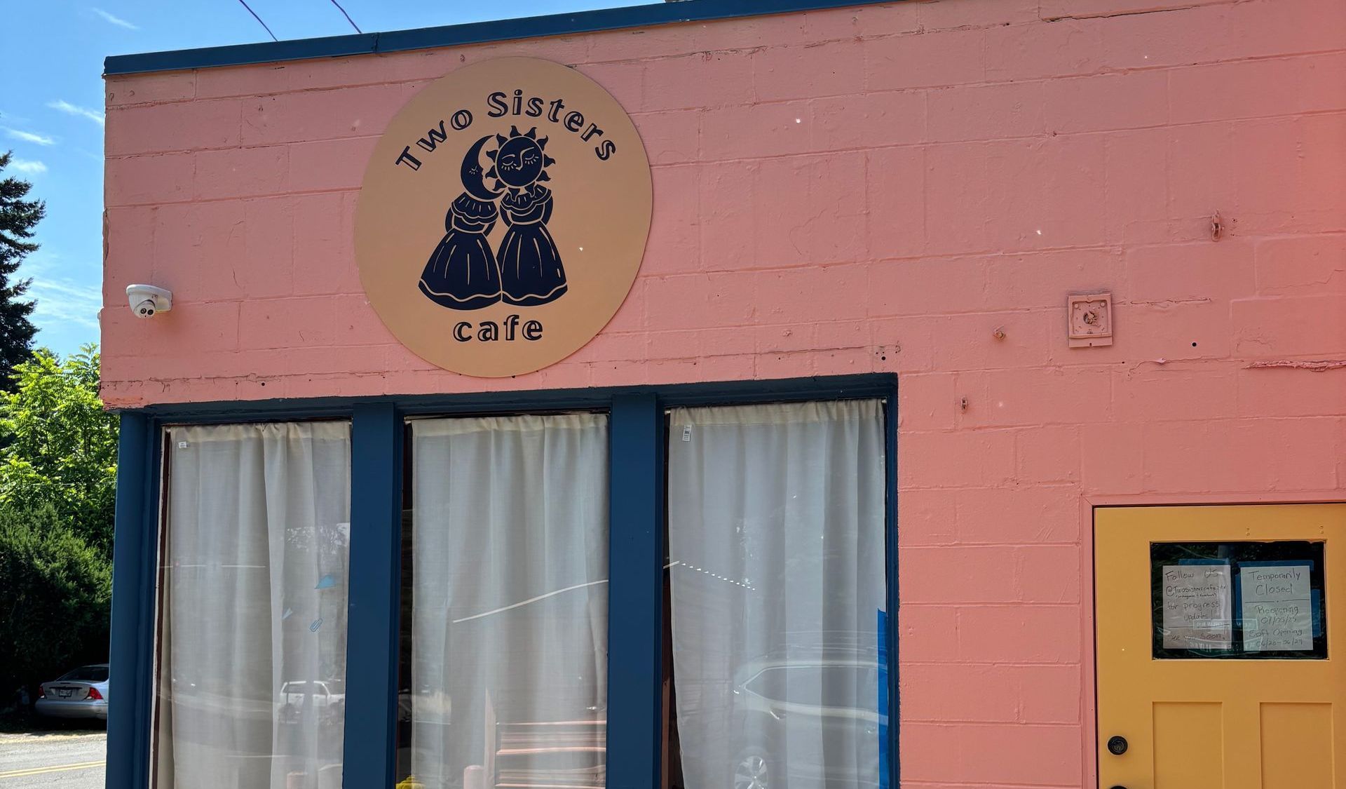 A pink building with a sign that says two sisters cafe