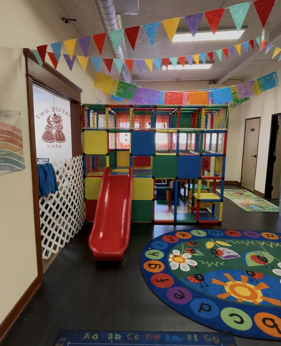 A room with a slide and a rug that says abc on it