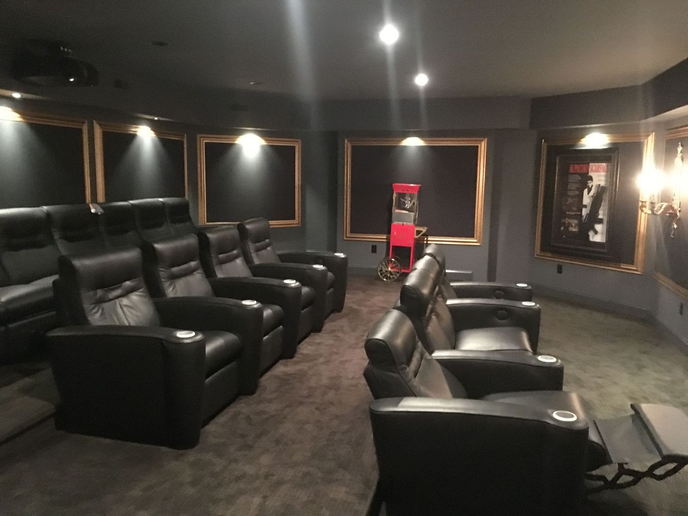 A row of black leather chairs in a home theater