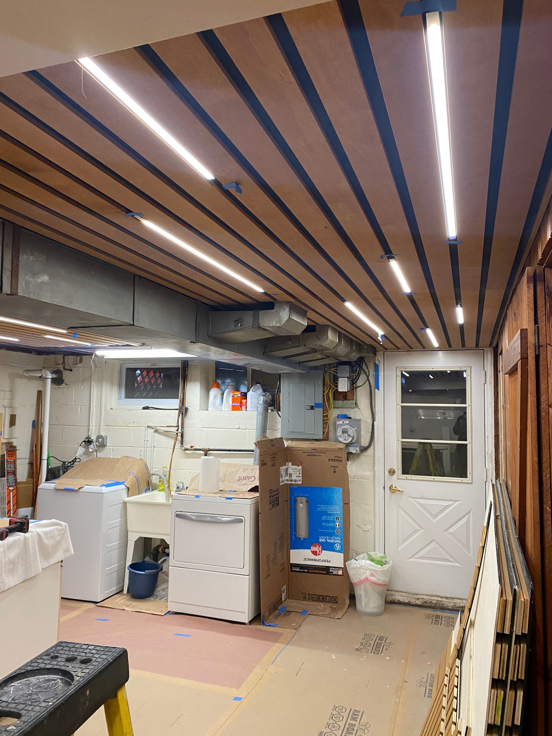 A laundry room with a wooden ceiling and appliances