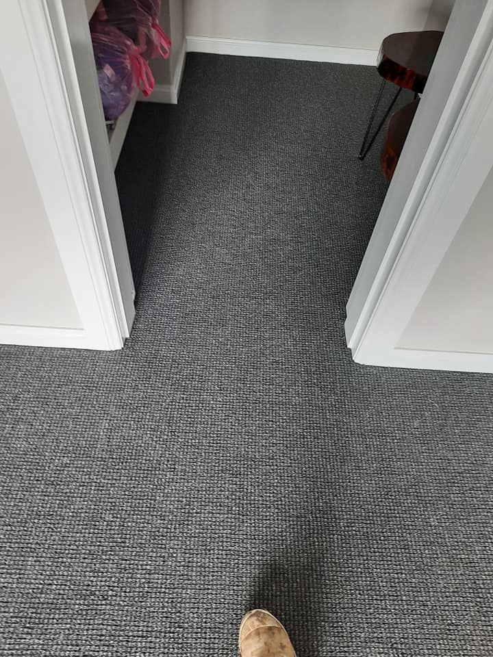 A person is standing on a carpeted floor in a closet