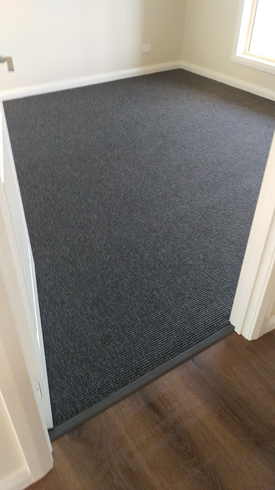 A room with a carpeted floor and a wooden floor