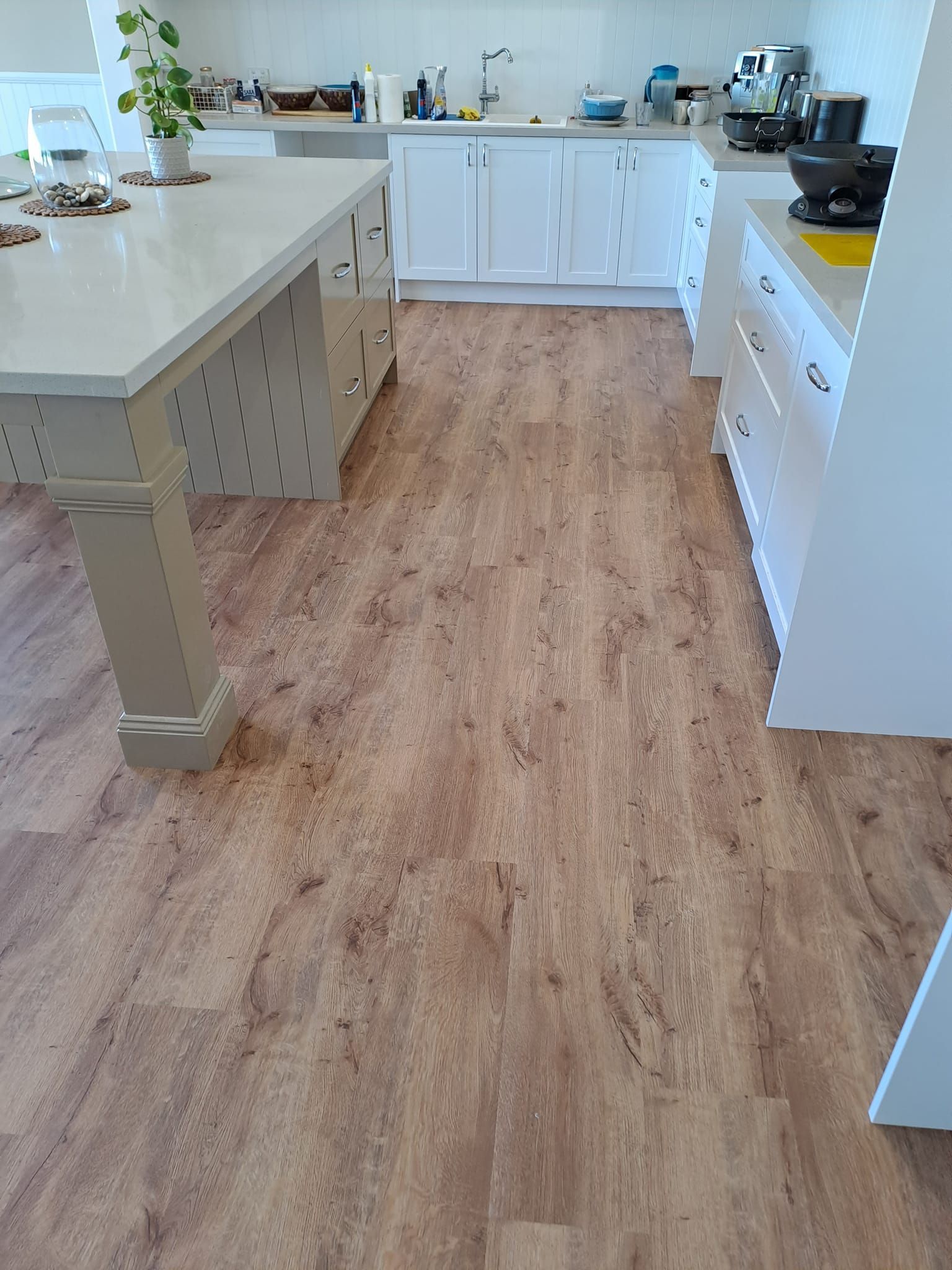 A kitchen with a wooden floor and white cabinets