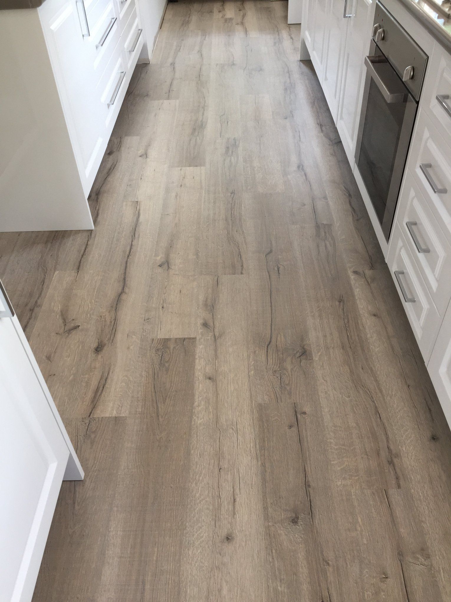 A kitchen with a wooden floor and white cabinets