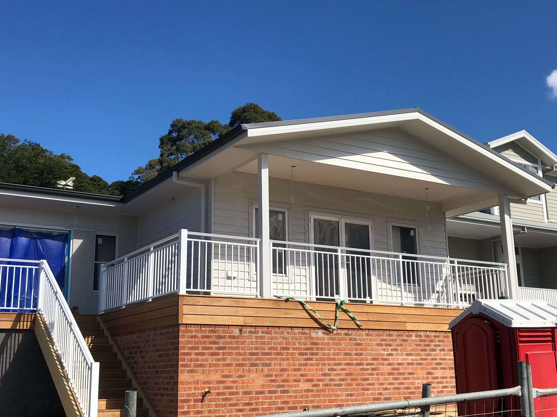 A large white house with a large balcony and stairs.