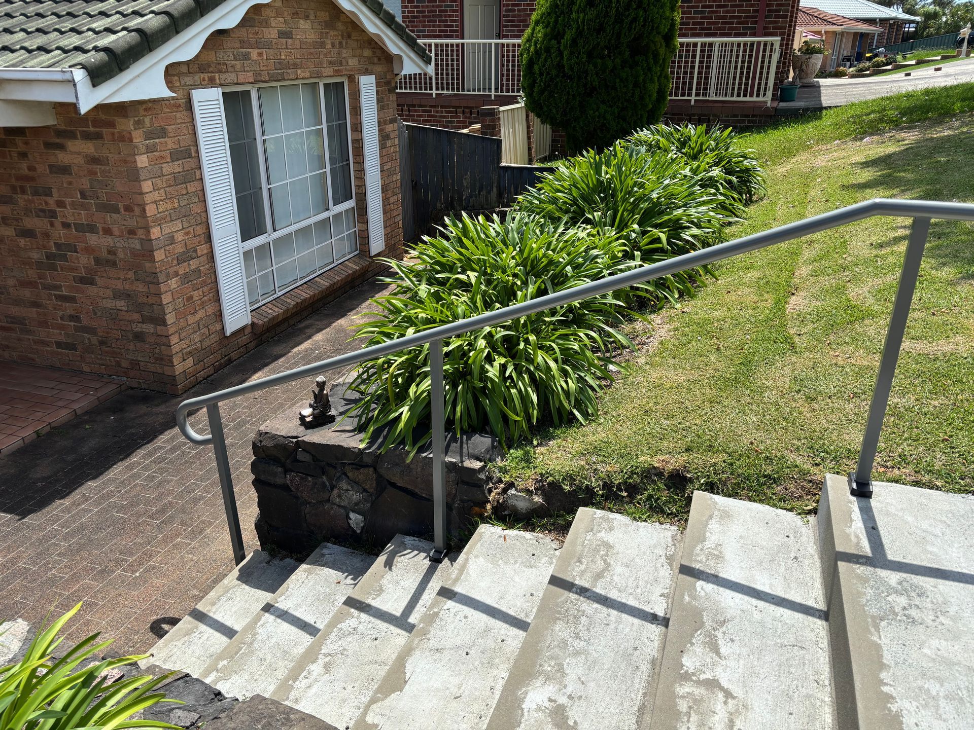 A set of stairs leading up to a house with a metal railing.