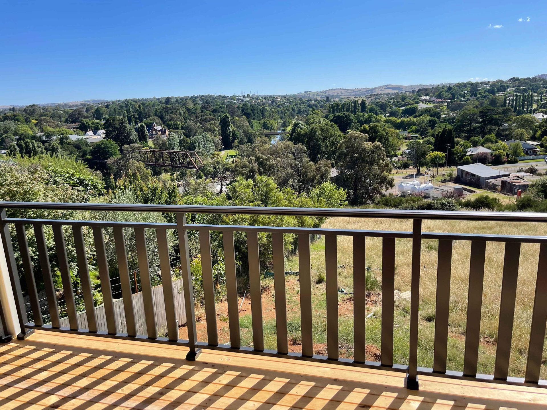 A balcony with a view of a city and trees