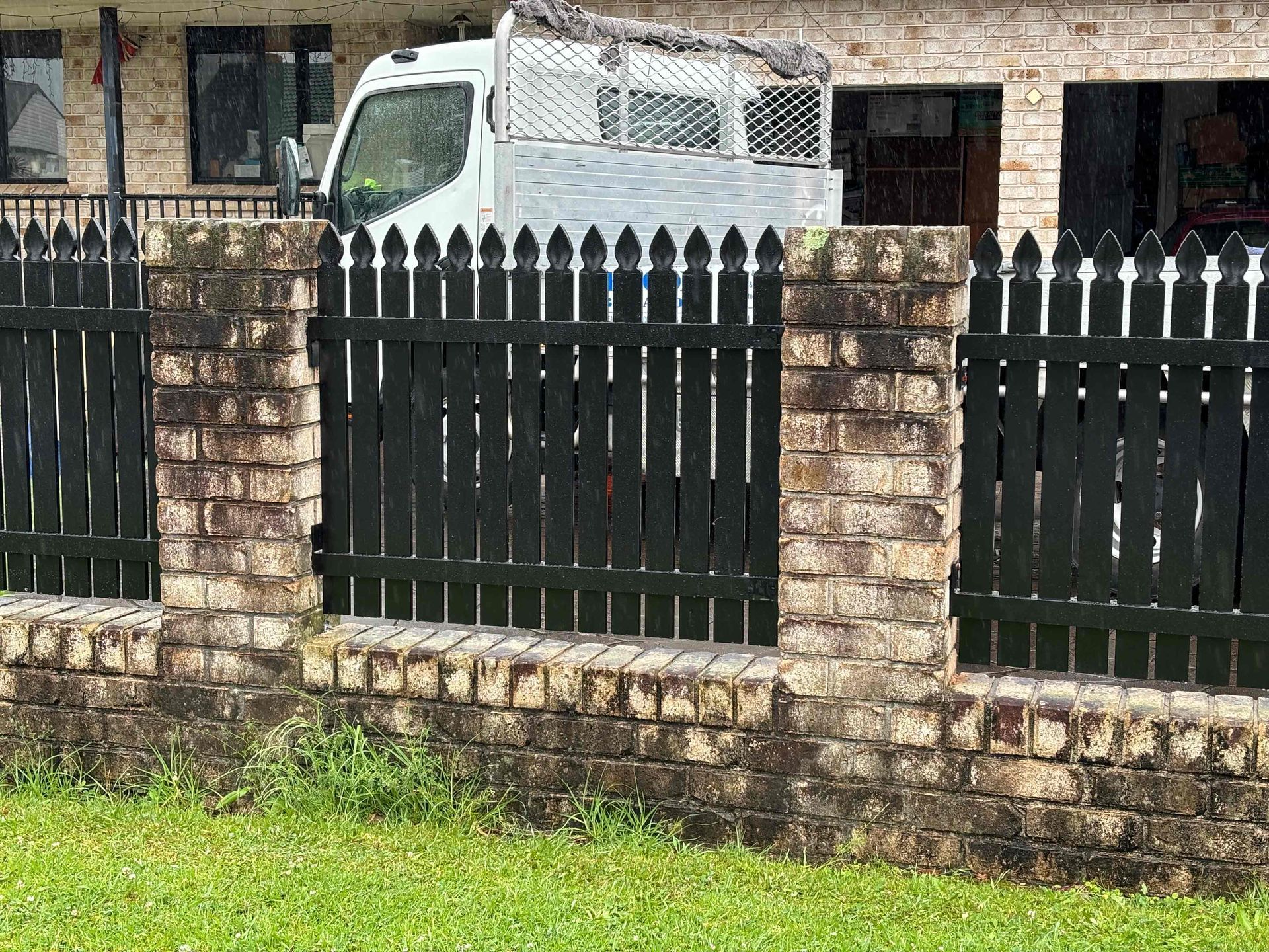 A balcony with a metal railing overlooking a lush green field.