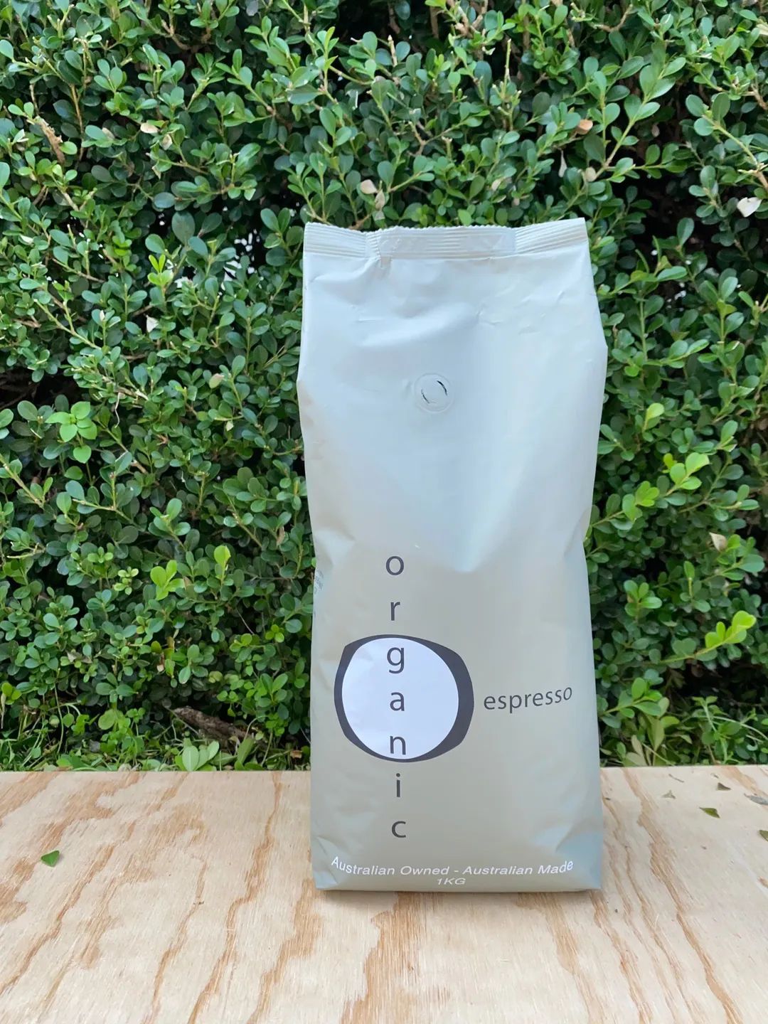 A Bag of Coffee Beans is Sitting on a Wooden Table — Labroco Gourmet Coffee Supplier In Forster, NSW