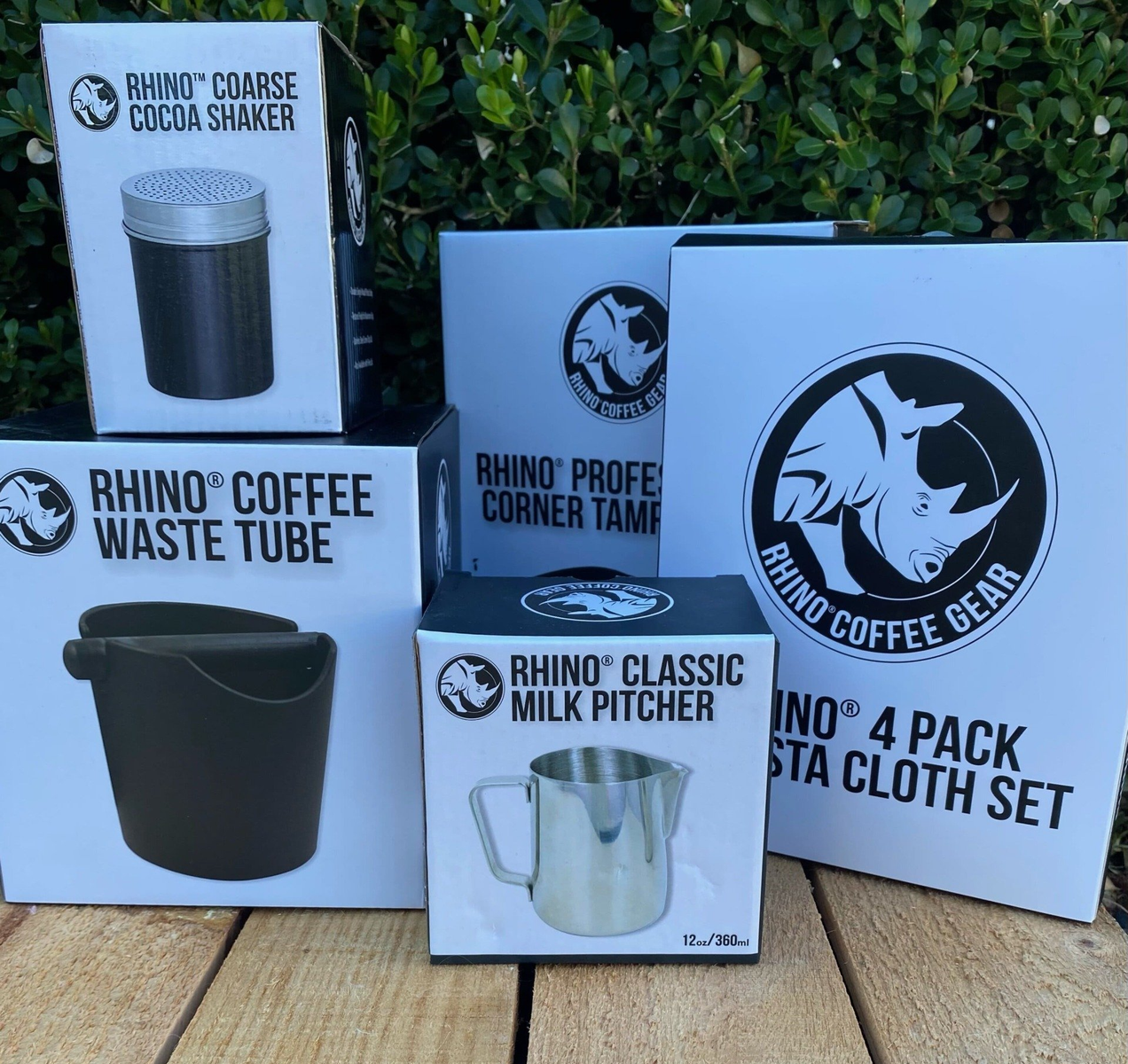 Rhino Coffee Gear products: cocoa shaker, waste tube, tamper, milk pitcher, and cloth set, on a wooden surface — Labroco Gourmet Coffee Supplier In Forster, NSW