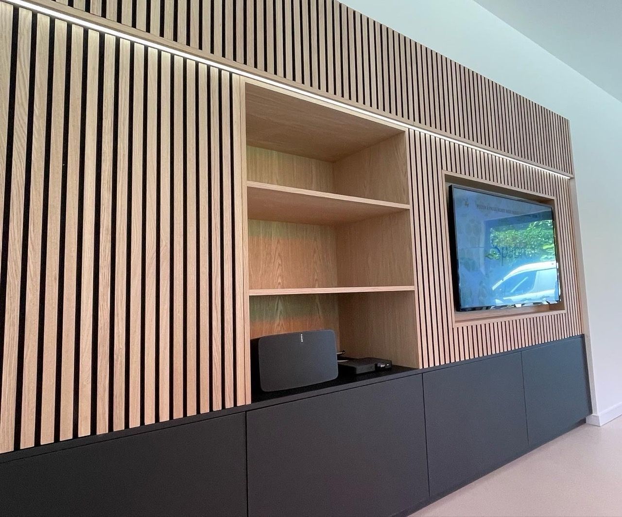 Een woonkamer met houten planken en een flatscreen-tv.