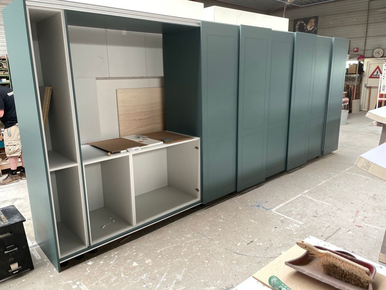 In een fabriek wordt een grote lege kast gebouwd.