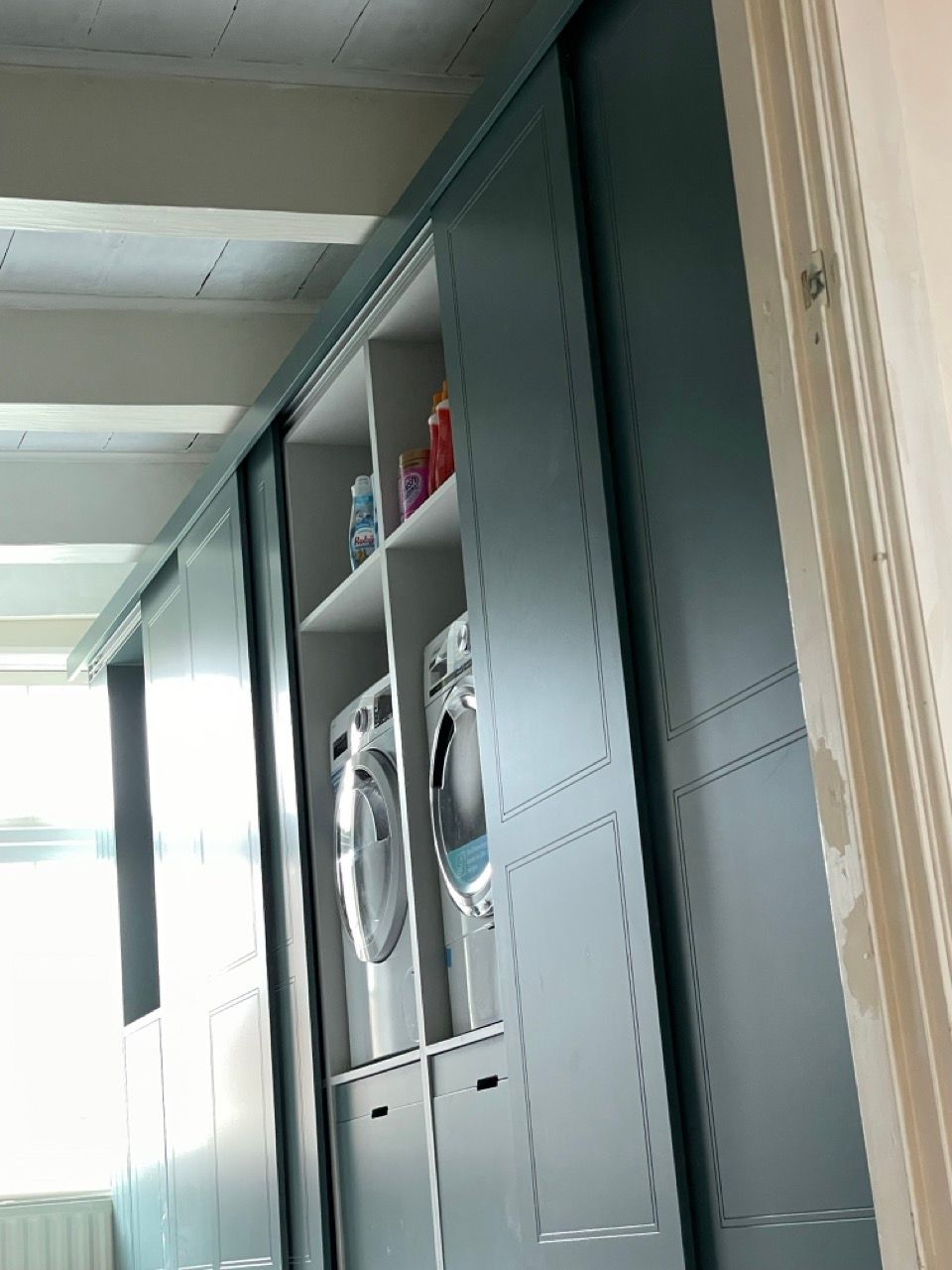 Een wasruimte met een wasmachine en droger erin