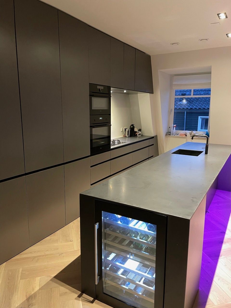 Een keuken met een groot kookeiland en een wijnkoeler