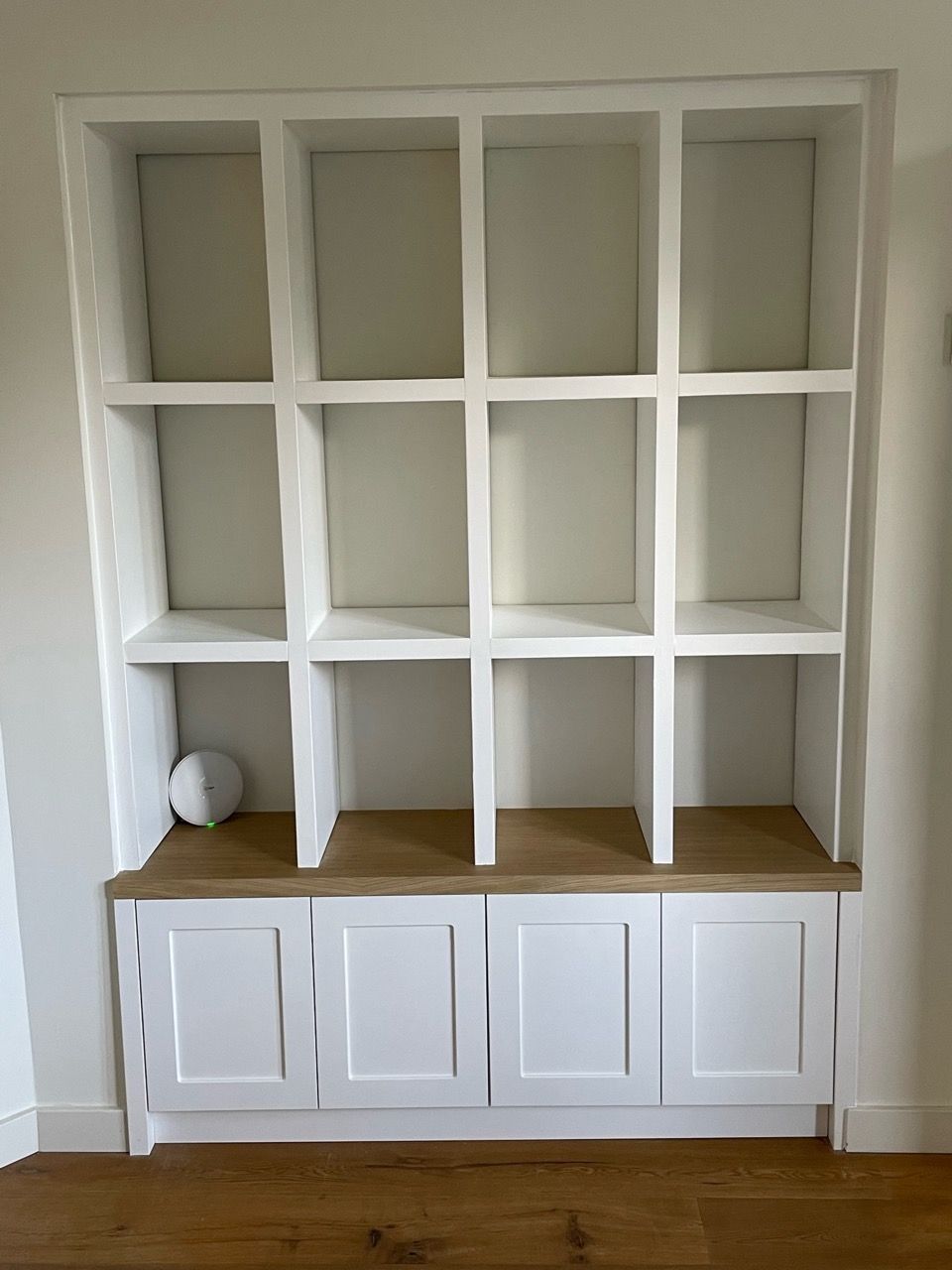 Stijlvolle maatwerk vitrinekast van Vuijst & Vuijst, met veelzijdige open vakken om kunstwerken en verzamelobjecten tentoon te stellen.