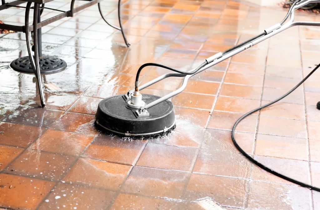 A person is cleaning a tiled floor with a machine.