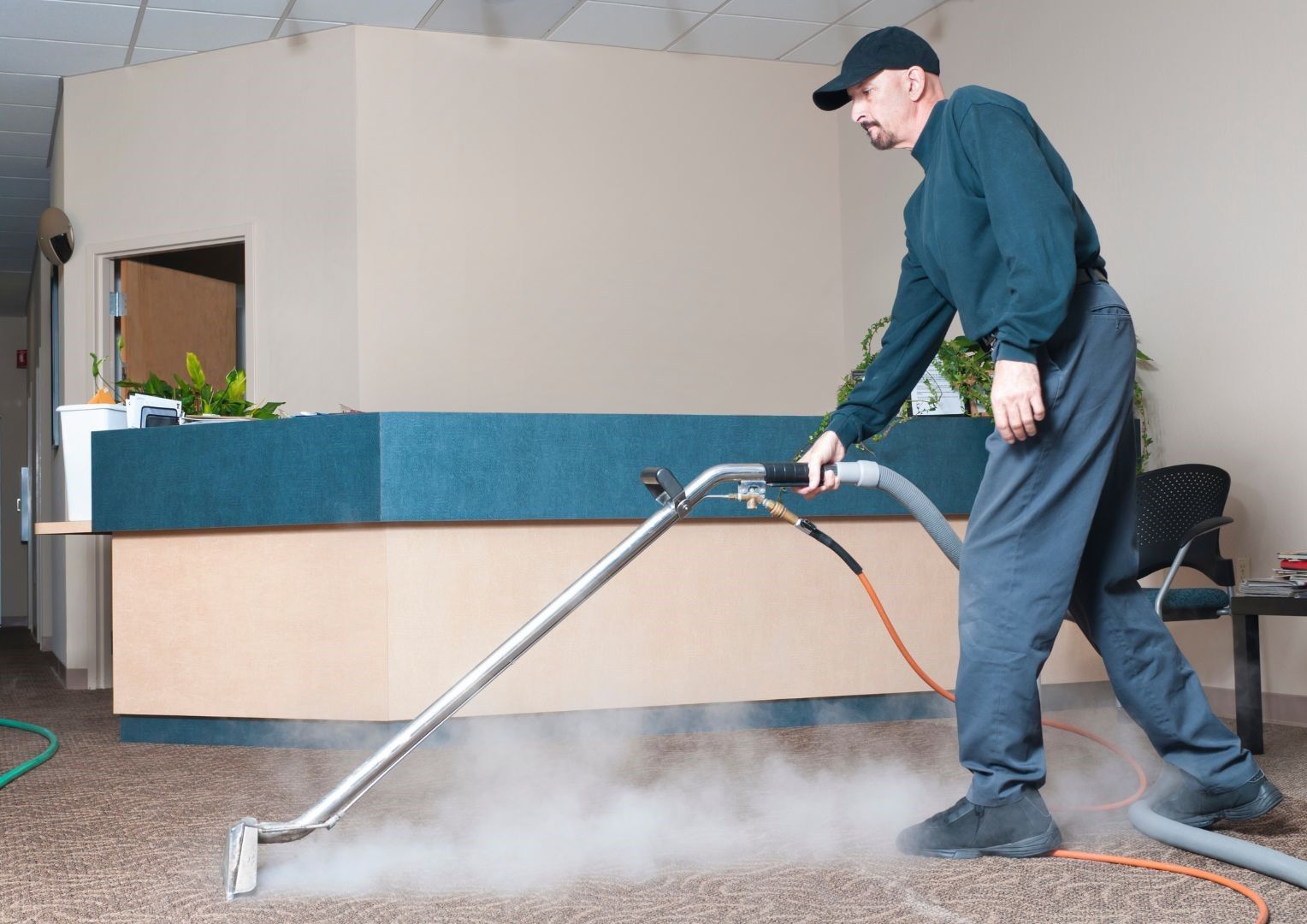 A man is using a vacuum cleaner to clean a carpet.