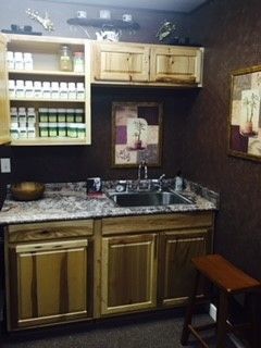 Wooden cabinets, granite counter tops, a sink and a stool