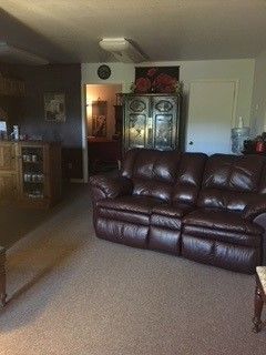A room with a brown leather couch and a coffee table