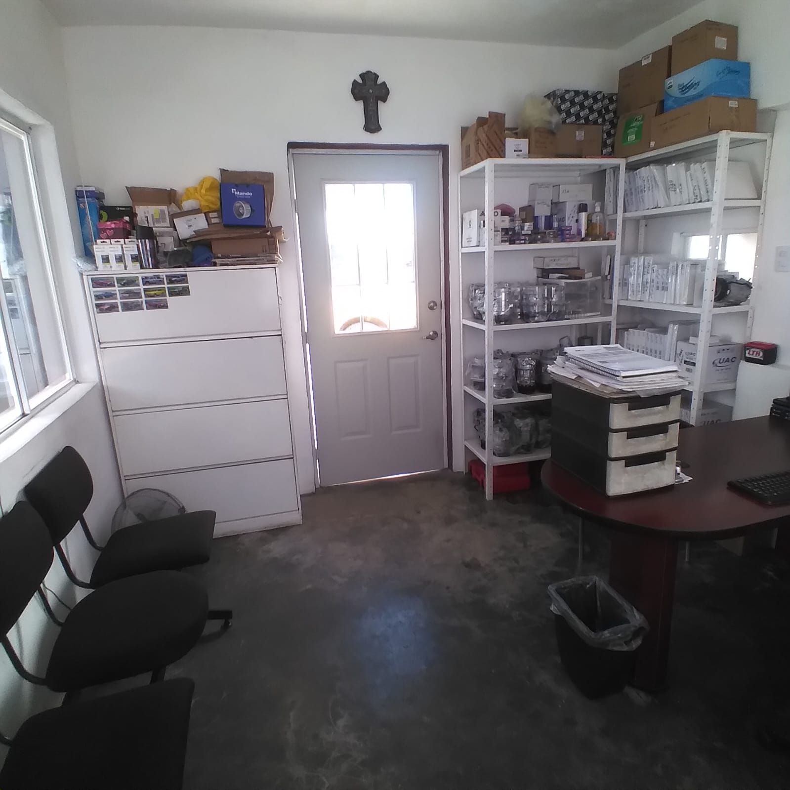 Una habitación con estantes y una cruz en la pared