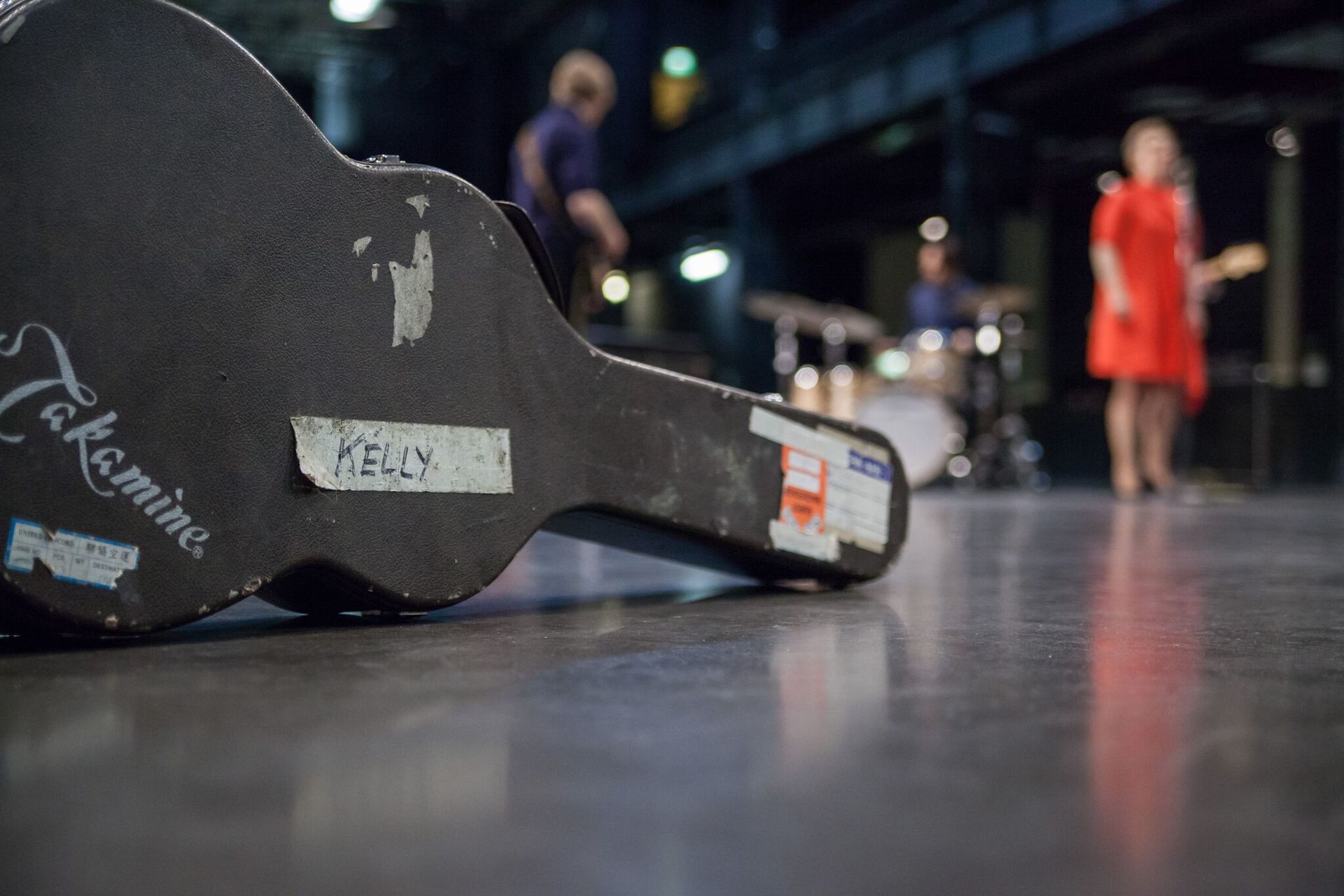 Auf dem Boden liegt ein Gitarrenkoffer mit Aufklebern.