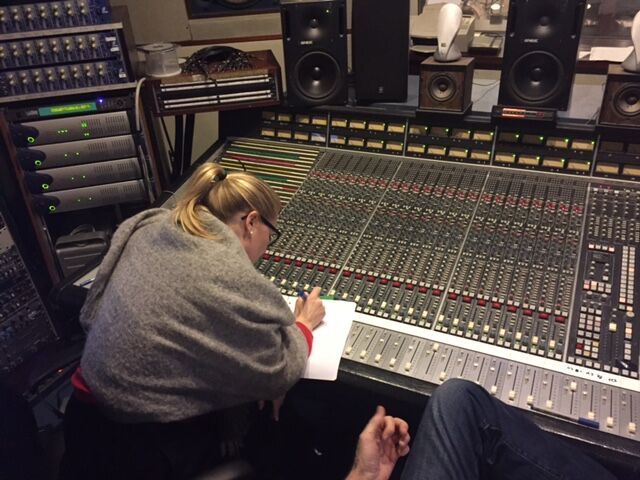 Eine Frau schreibt auf einem Blatt Papier vor einem Mixer