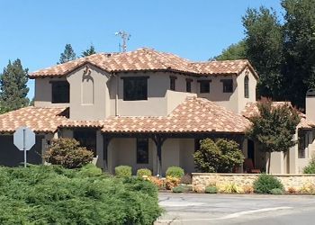 a large house with a tile roof and a stop sign in front of it .