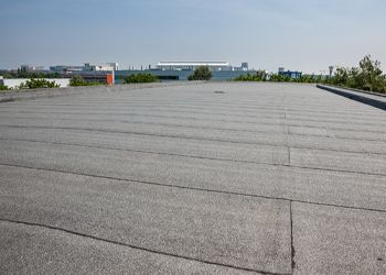 a roof with a flat roof and a building in the background .