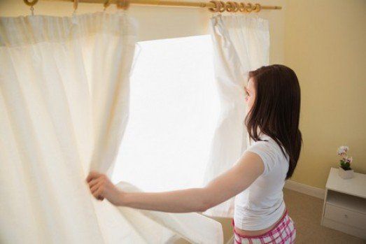 Woman Opening Curtains — Window Blinds in Red Bank, NJ