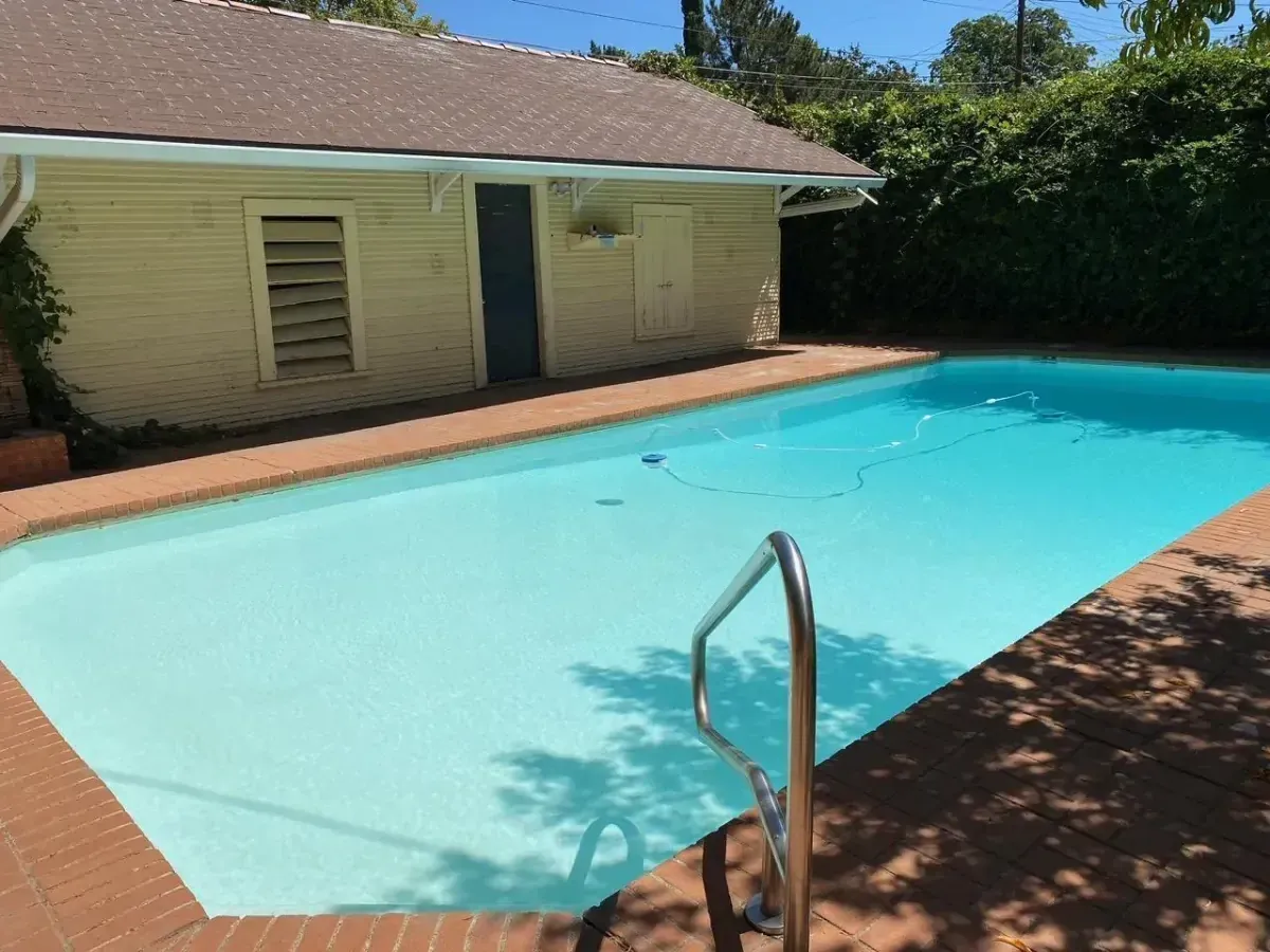 A large swimming pool in front of a house